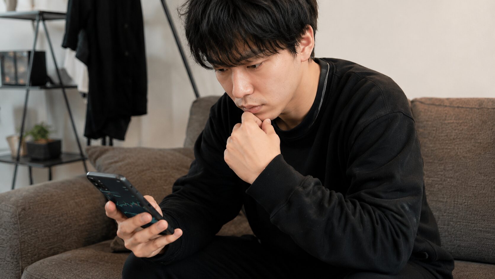 スマホで自分の音域を測る20代男性会社員の真剣な表情