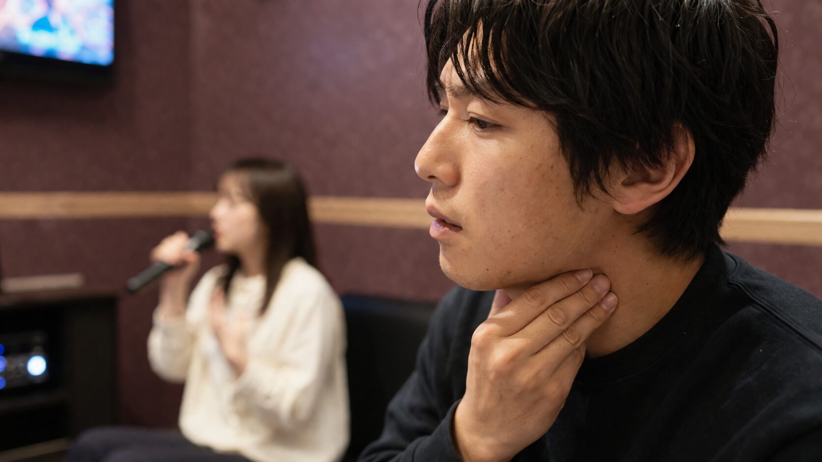 低音で喉に違和感を覚え原因を探る男性の横顔